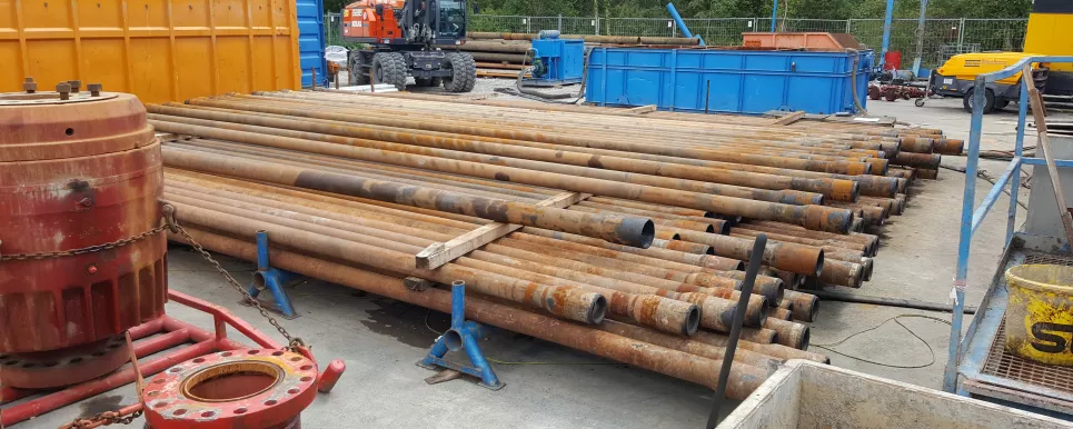 Bohrgestänge: mehrere, lange Metallrohre liegen gestapelt übereinander